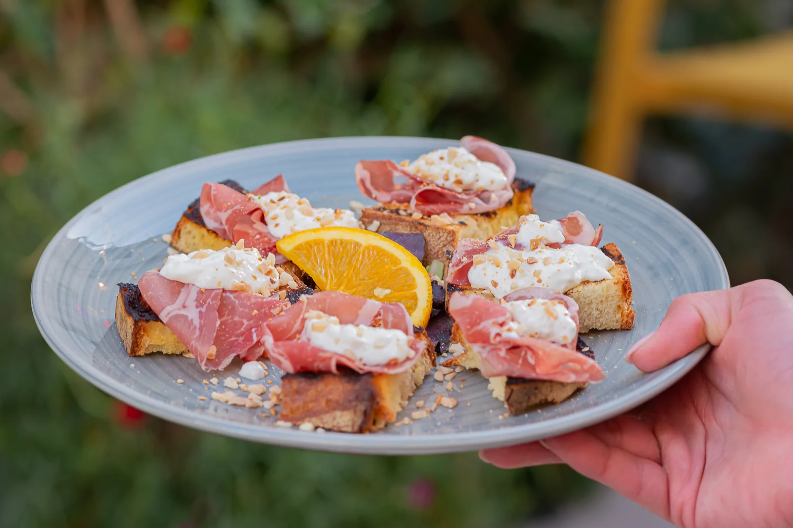 Due piatti di bruschette con salumi, formaggi e agrumi